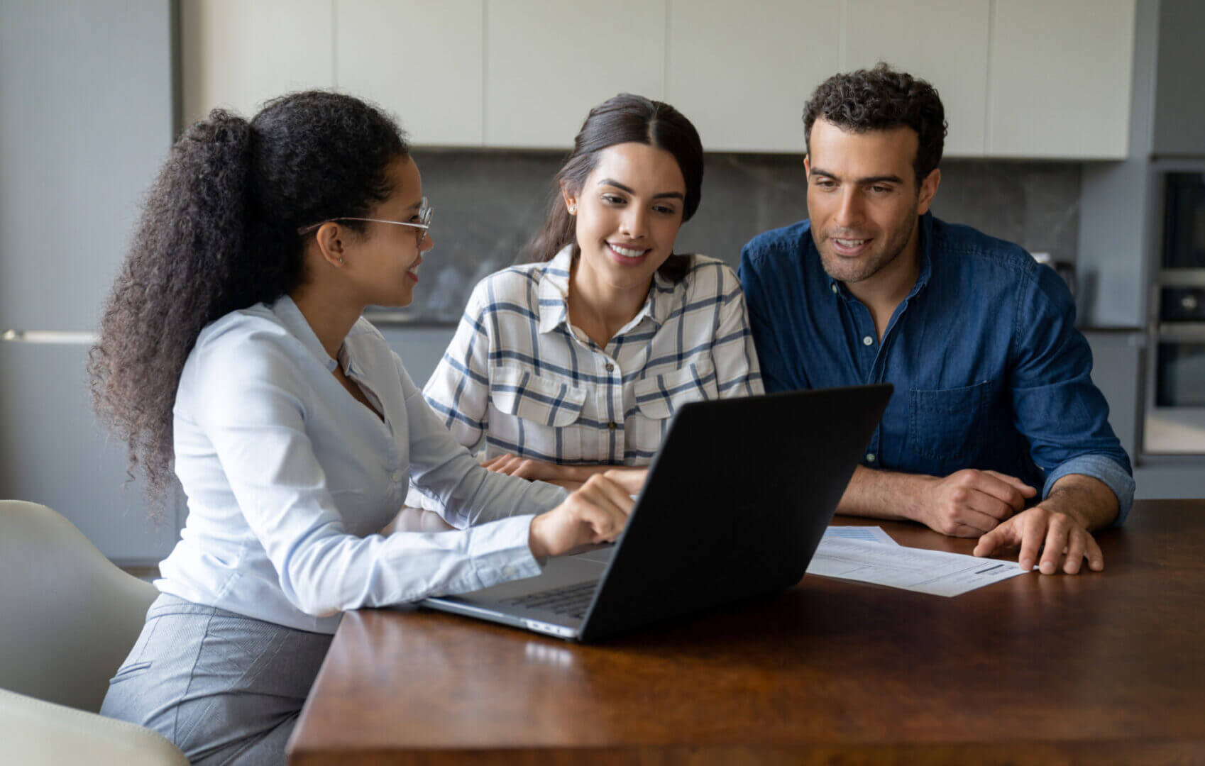 People collaborating at a table with laptop.