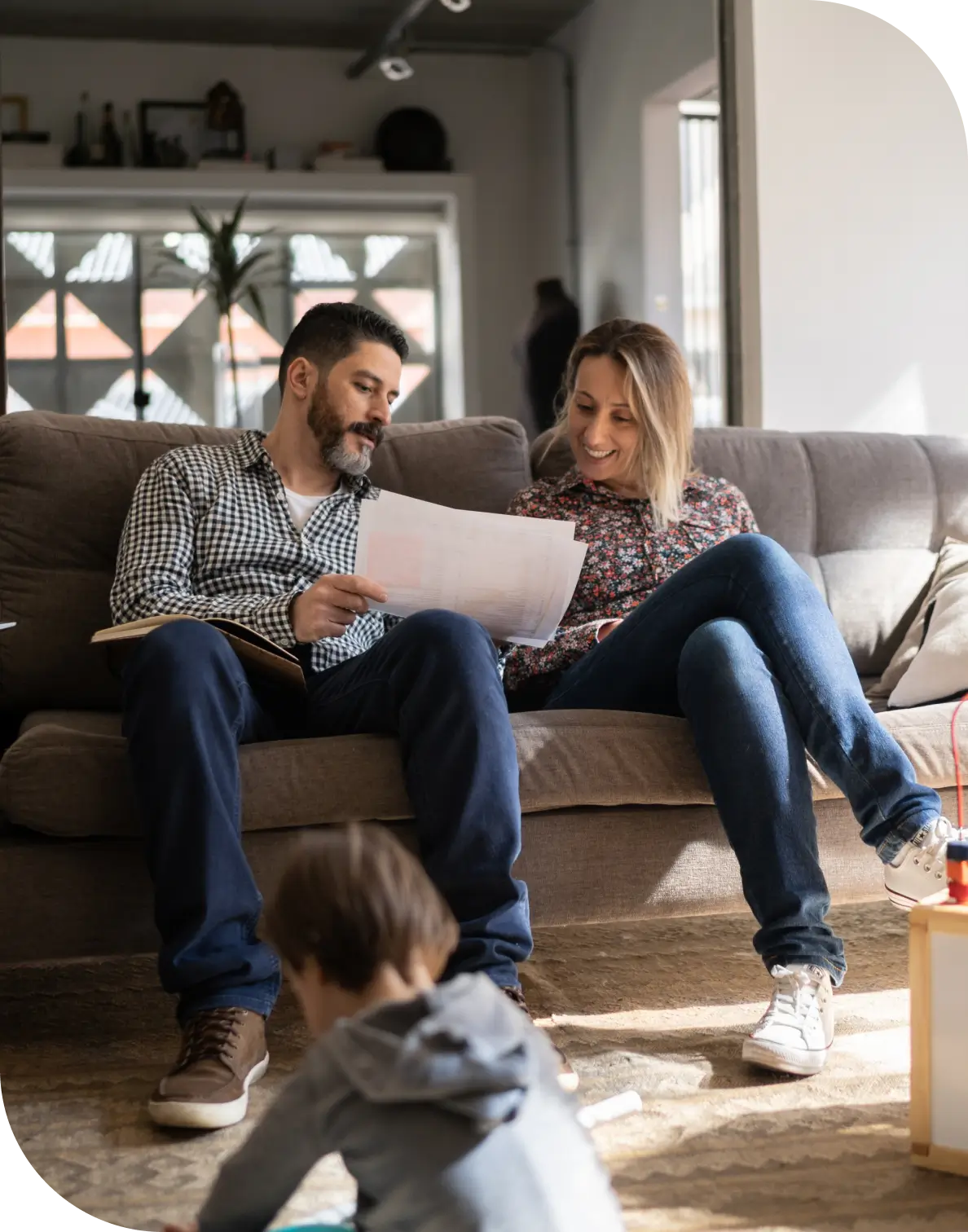 Couple reviewing documents on couch with child